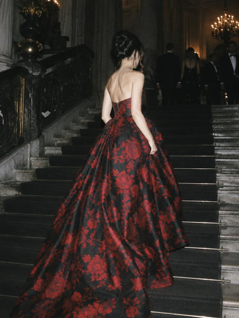 Red and black floral ballgown on a dark staircase